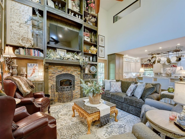 living room with a healthy amount of sunlight, a fireplace, and a high ceiling