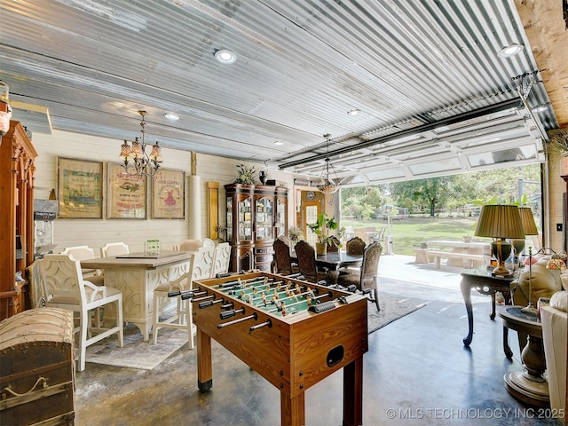 playroom with recessed lighting, a notable chandelier, and concrete floors