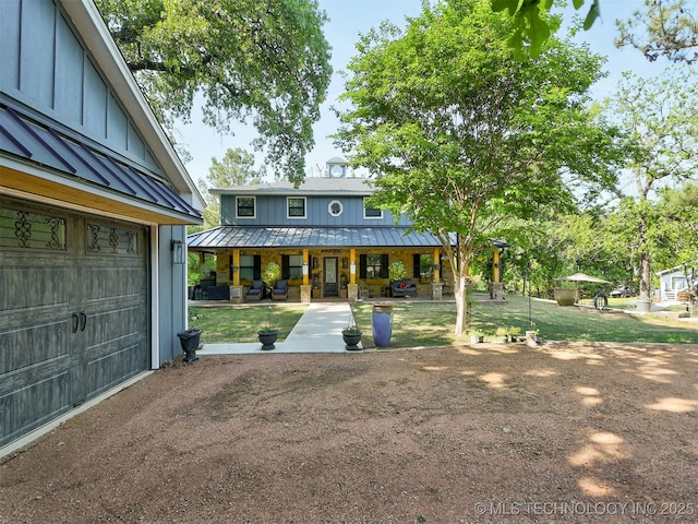 view of front of house featuring a porch, board and batten siding, a standing seam roof, metal roof, and a garage