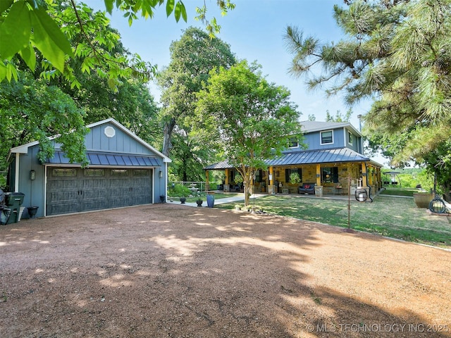 farmhouse inspired home featuring board and batten siding, a standing seam roof, metal roof, and a garage