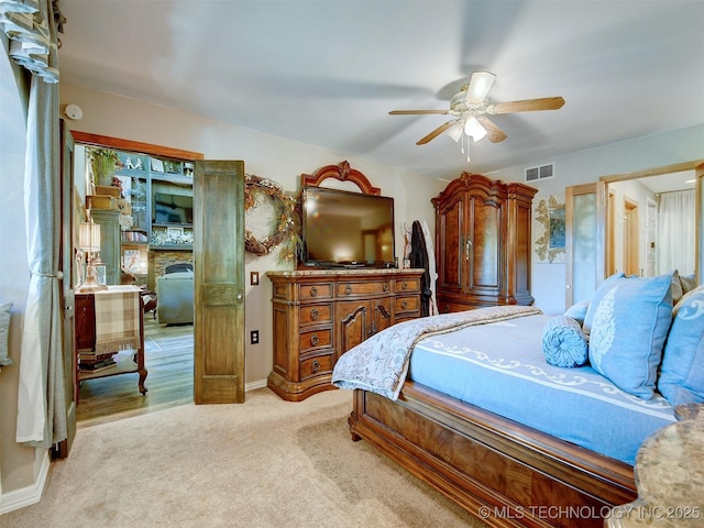 bedroom featuring light colored carpet, visible vents, ceiling fan, and baseboards