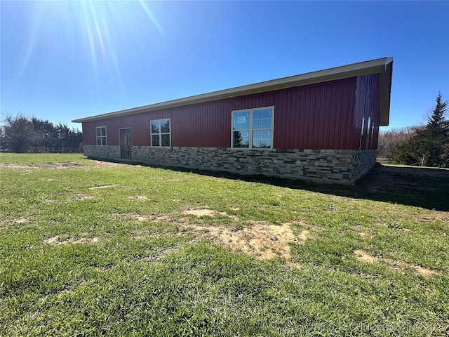 view of property exterior with a yard and stone siding