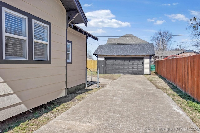 view of side of property with a garage, an outdoor structure, and fence