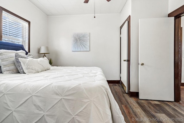 bedroom featuring dark wood-style floors, ceiling fan, ornamental molding, and baseboards