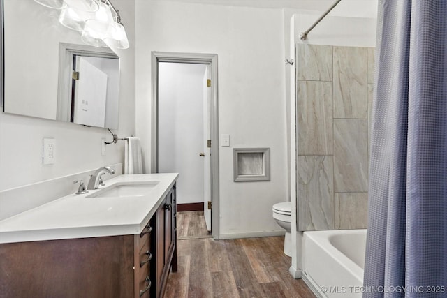 full bathroom featuring toilet, wood finished floors, vanity, baseboards, and shower / tub combo with curtain
