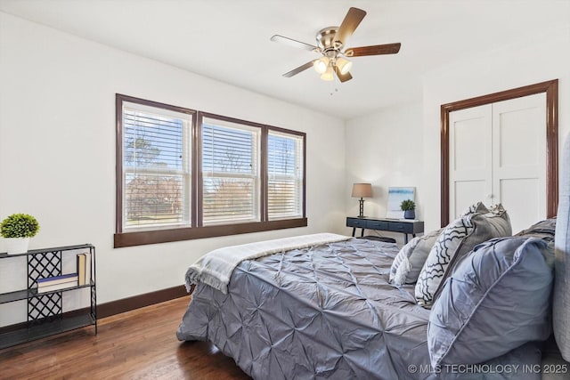 bedroom featuring a ceiling fan, baseboards, and wood finished floors