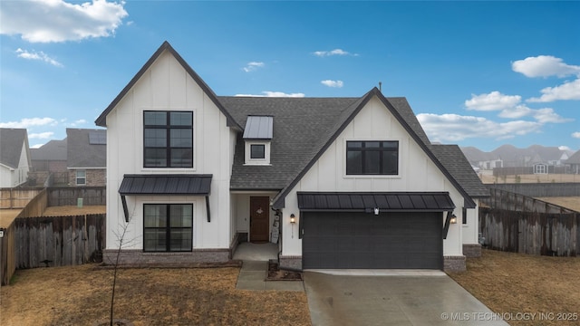 modern farmhouse with a shingled roof, fence, driveway, board and batten siding, and a standing seam roof