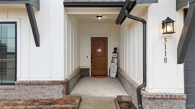 view of exterior entry with a shingled roof