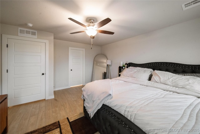 bedroom featuring light wood-style floors, visible vents, ceiling fan, and baseboards