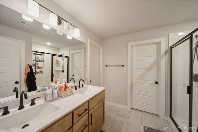 full bath with double vanity, a stall shower, a sink, and visible vents