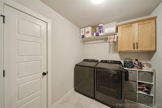 laundry room with light tile patterned floors, independent washer and dryer, cabinet space, and baseboards