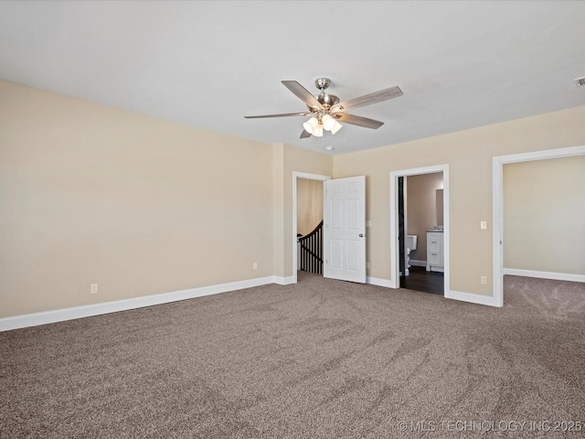 unfurnished bedroom with carpet floors, ensuite bath, baseboards, and a ceiling fan