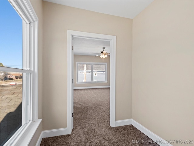 hallway featuring carpet floors and baseboards