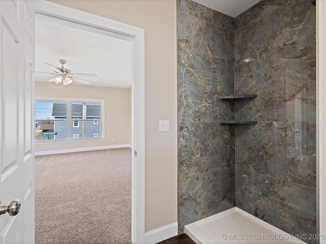 full bath with tiled shower, a ceiling fan, and baseboards