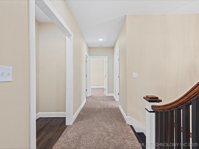 corridor with stairway, baseboards, and carpet flooring