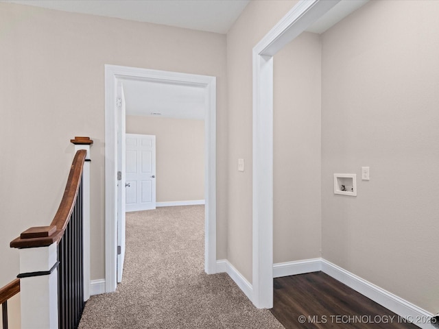 hall with dark colored carpet, baseboards, and an upstairs landing