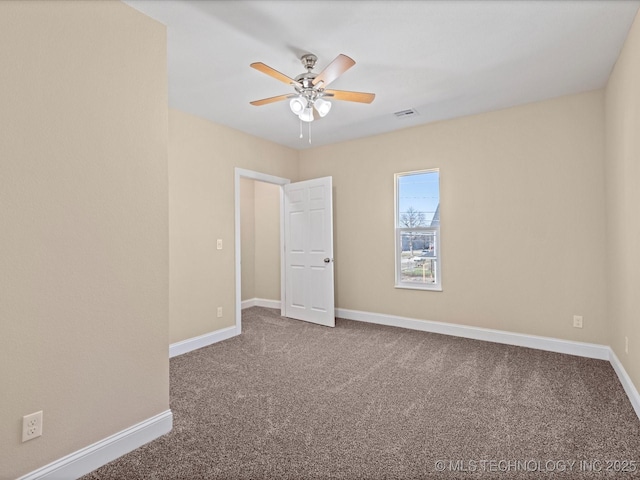 carpeted empty room featuring baseboards and a ceiling fan