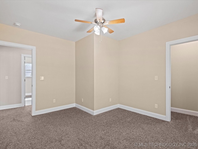 spare room featuring dark carpet, a ceiling fan, and baseboards