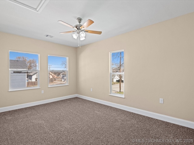 unfurnished room with carpet, baseboards, visible vents, and a ceiling fan