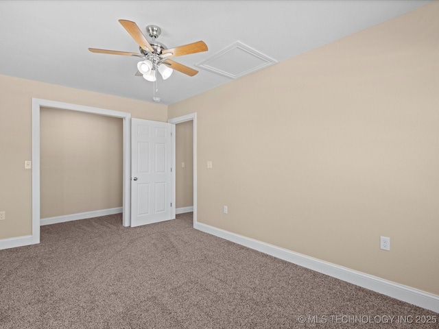 unfurnished bedroom featuring attic access, carpet flooring, baseboards, and a ceiling fan