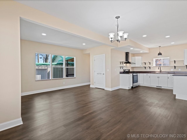 kitchen featuring dark countertops, a sink, wall chimney exhaust hood, and stainless steel electric stove