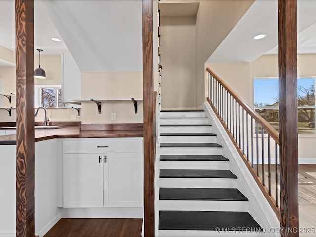 staircase featuring recessed lighting, baseboards, and wood finished floors