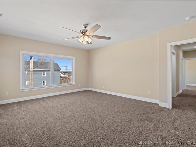 carpeted spare room featuring visible vents, baseboards, and a ceiling fan