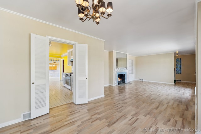 unfurnished living room with light wood-style floors, a fireplace with flush hearth, visible vents, and ornamental molding