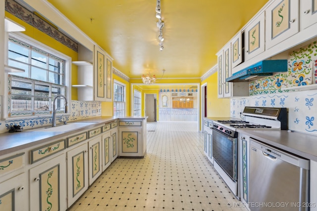 kitchen featuring gas range gas stove, light floors, a sink, dishwasher, and a peninsula