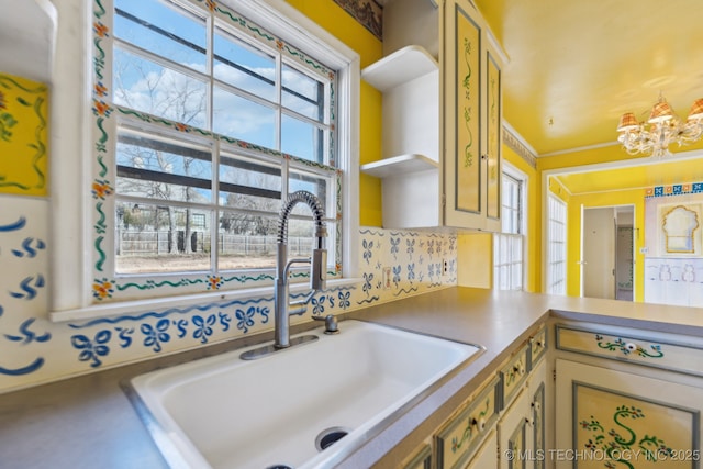 kitchen featuring an inviting chandelier, open shelves, and a sink