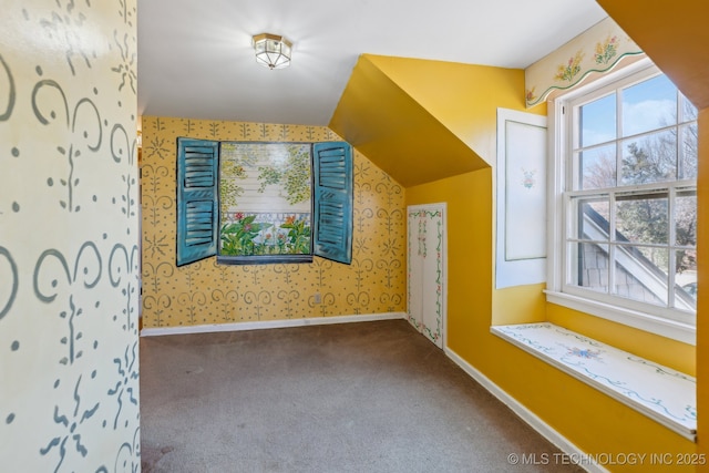 additional living space with lofted ceiling, carpet flooring, baseboards, and wallpapered walls