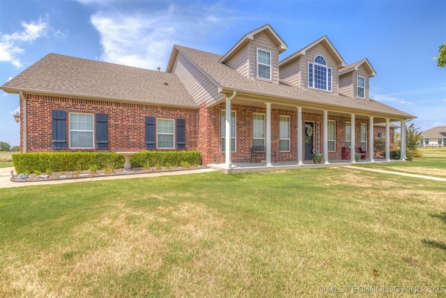 cape cod home with roof with shingles, brick siding, and a front lawn