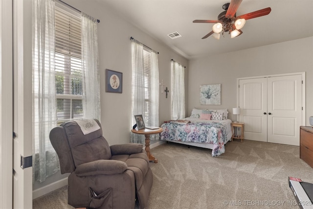 carpeted bedroom featuring ceiling fan, a closet, visible vents, and baseboards