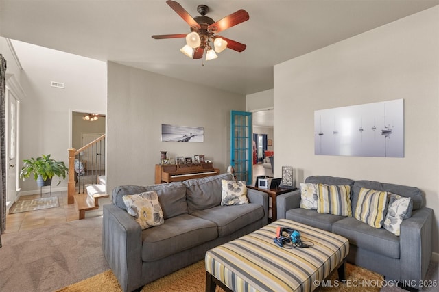 living room with a ceiling fan, light colored carpet, and stairway