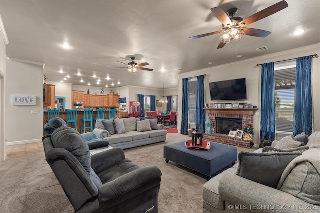 living area featuring a ceiling fan, visible vents, crown molding, and light tile patterned flooring