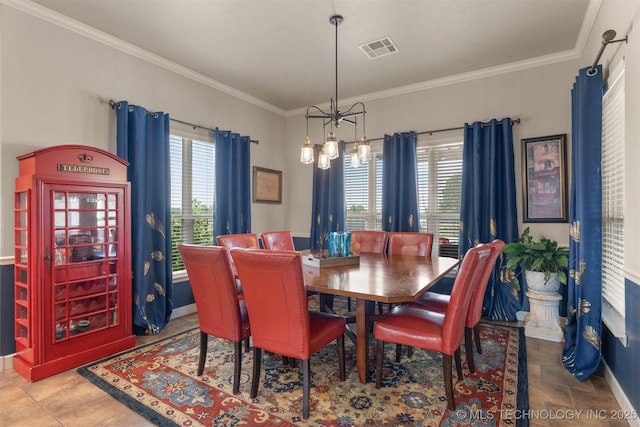 dining room featuring ornamental molding, a wealth of natural light, visible vents, and baseboards