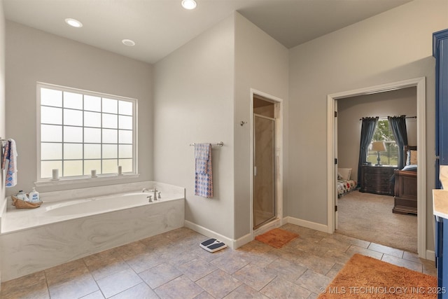 ensuite bathroom with baseboards, ensuite bath, a shower stall, a bath, and recessed lighting