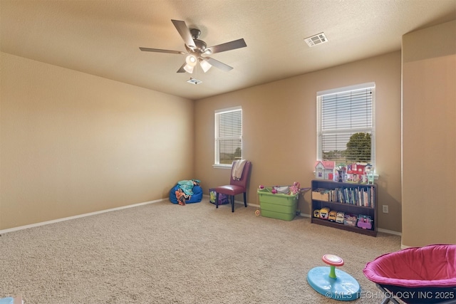 playroom featuring a ceiling fan, baseboards, visible vents, and carpet flooring