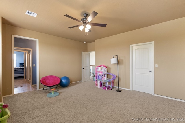 game room with carpet floors, baseboards, visible vents, and a ceiling fan