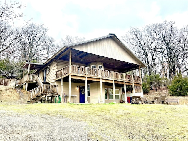 back of house featuring a deck, a lawn, and stairway