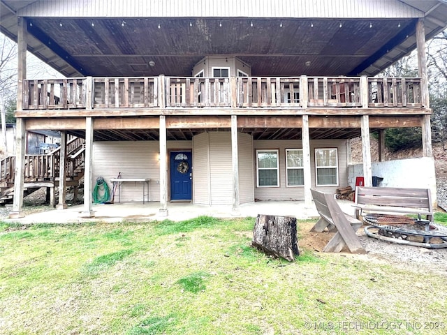 rear view of house with a patio, a lawn, stairway, an outdoor fire pit, and a deck