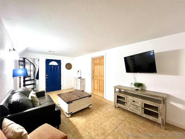 living area featuring a textured ceiling and light tile patterned flooring