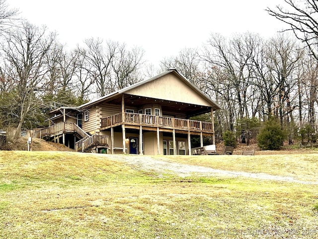 back of house with a deck, stairway, a lawn, and log exterior