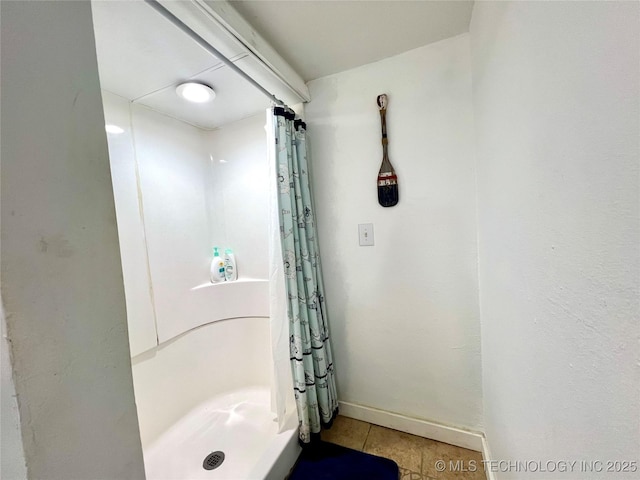 bathroom featuring a stall shower, baseboards, and tile patterned floors