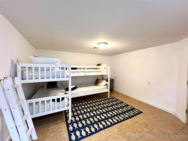 bedroom with baseboards and a textured ceiling