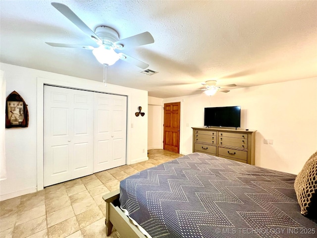bedroom with a closet, visible vents, ceiling fan, and a textured ceiling