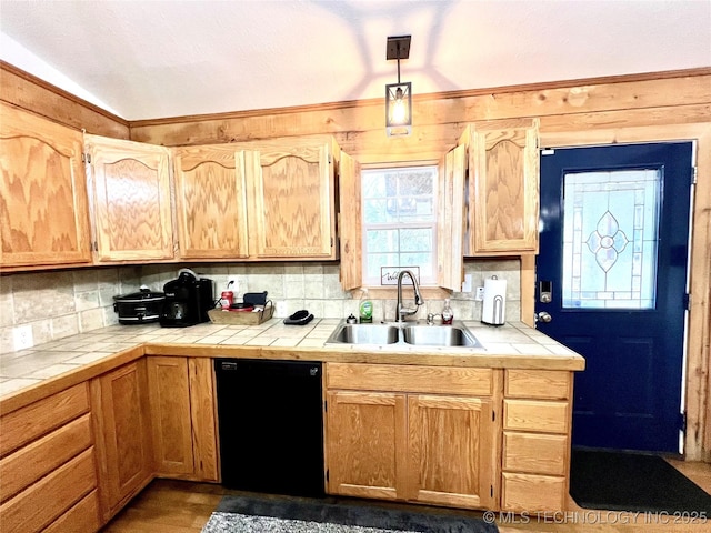 kitchen featuring black dishwasher, tile counters, tasteful backsplash, and a sink
