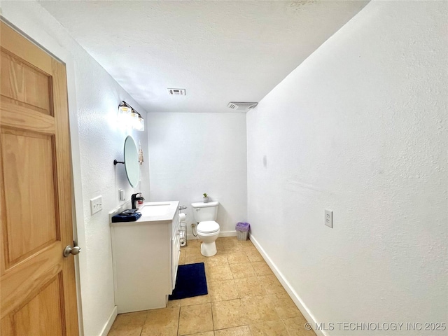bathroom featuring toilet, visible vents, baseboards, and vanity