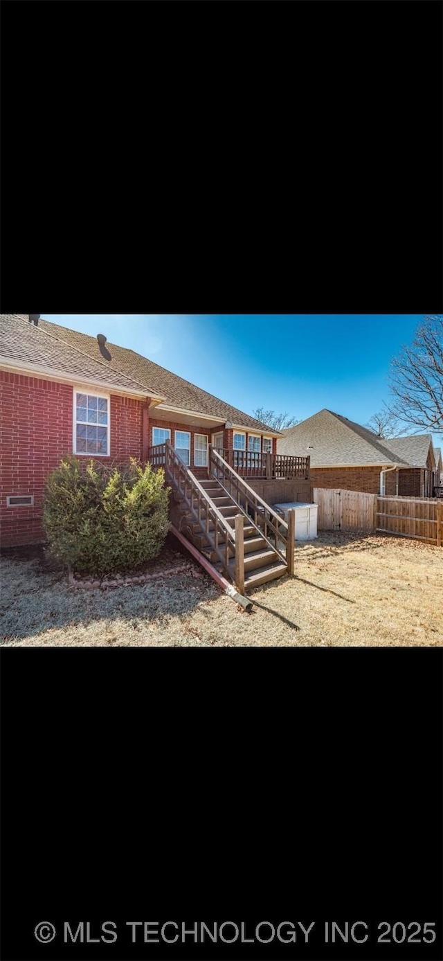 view of front of property featuring brick siding, fence, and stairs