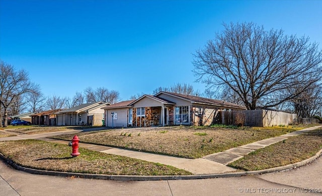 ranch-style house featuring concrete driveway and fence